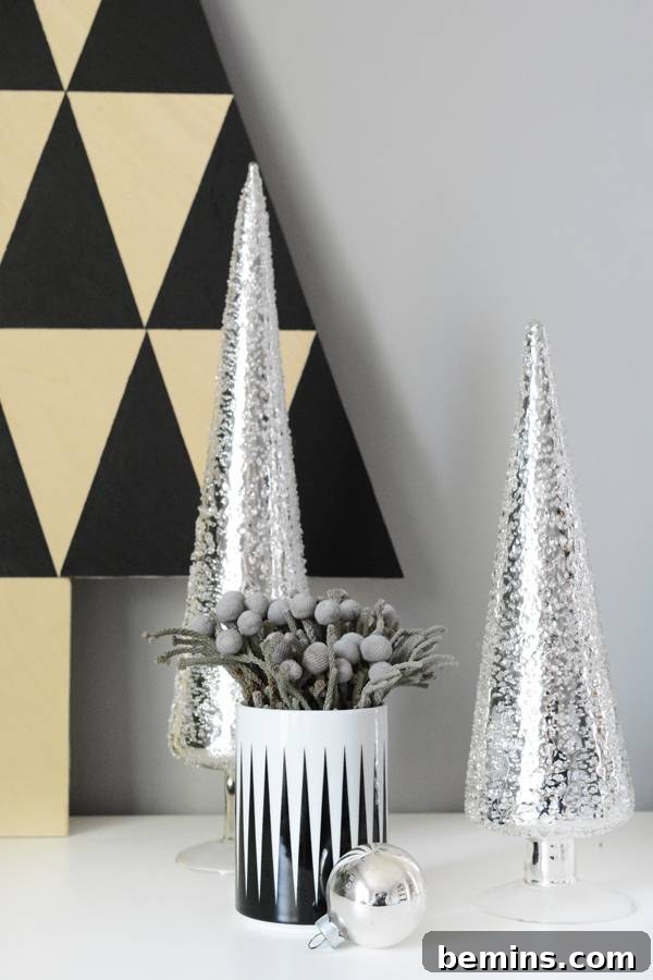 Chrome Christmas tree next to a flower pot, showcasing modern Christmas decor ideas.