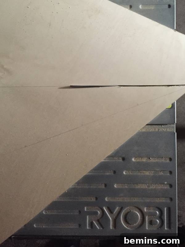 A worn car mat with a piece of paper covering it, showing the initial drawing of the tree outline.