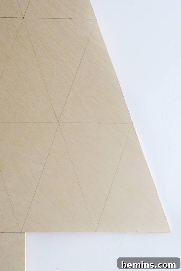 A geometric, beige piece of cardboard that looks like half a tree, showcasing the cut-out tree shape.