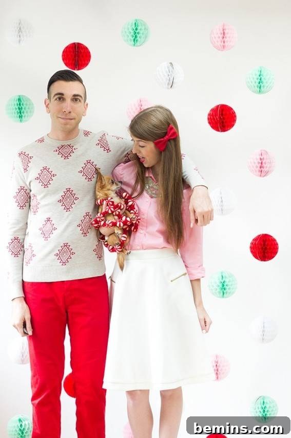 Couple with baby in front of colorful honeycomb ball background - DIY Holiday Photo Backdrop