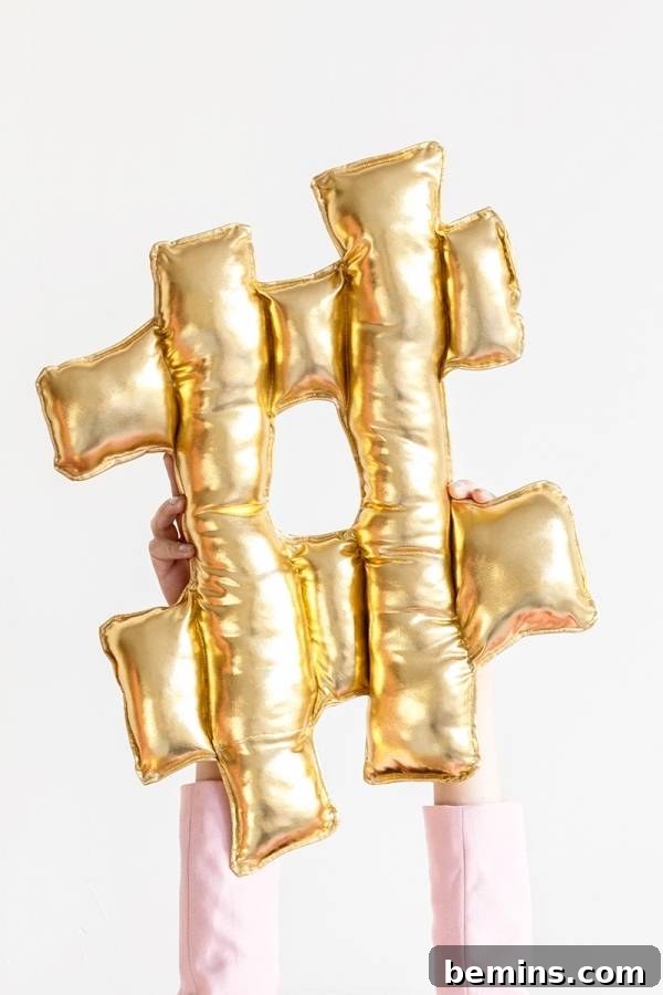 A person holding a shimmering gold balloon letter pillow