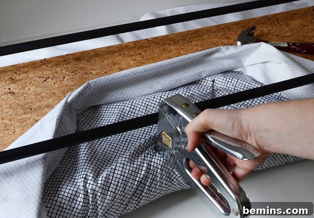 Stapling the fabric to the underside of the bench