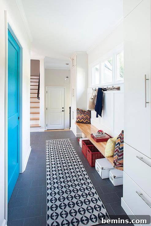 Long white mudroom with plastic baskets under the wooden bench.
