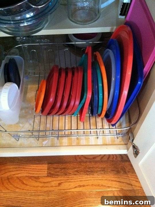Tupperware lid organization using dividers in the cabinet.