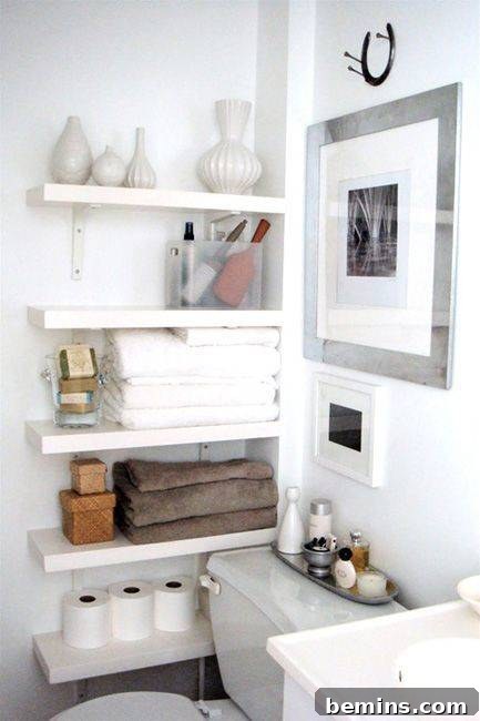 A white bathroom featuring a shelf filled with towels and tissue papers.