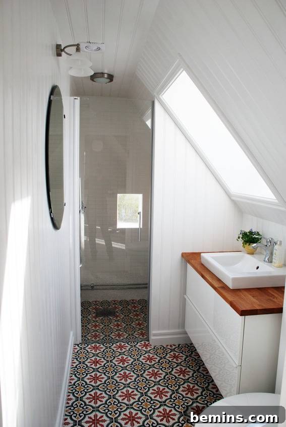 A bathroom with a vanity placed under a slanted ceiling.