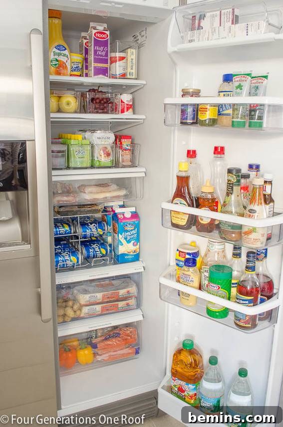 Refrigerator organized with clear storage bins containing various food items