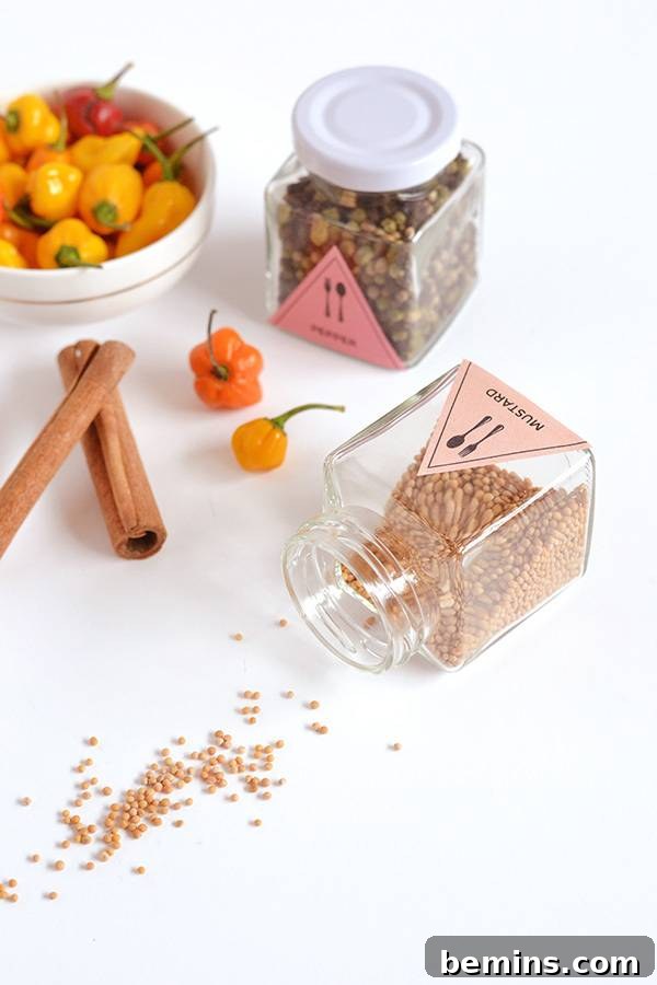 A close-up shot of spices stored in glass jars alongside fresh vegetables in a bowl, showcasing an organized and visually appealing kitchen setup.