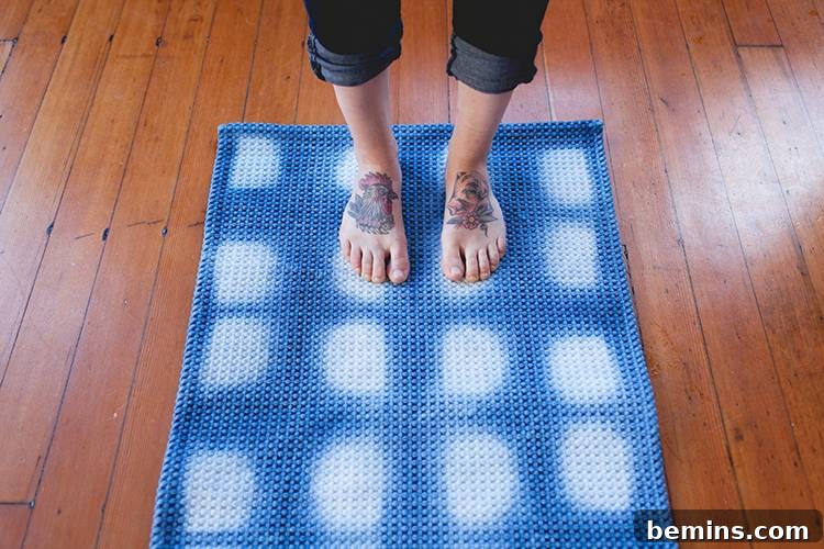 7 Creative DIY Projects to Tackle This Weekend 4 A close-up of tattooed feet standing on a beautifully dyed blue and white Shibori style bath mat, adding a touch of artistry to your bathroom.