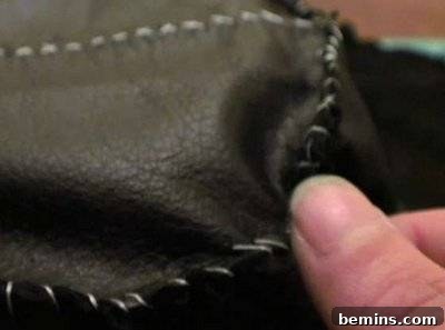A person preparing the pirate costume out of black fabric.