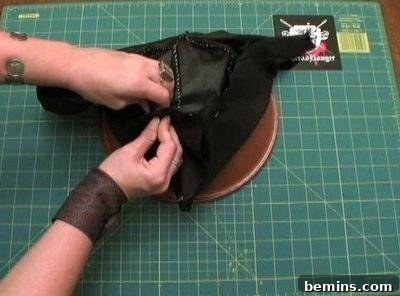 Hands holding the nearly finished tricorn hat.