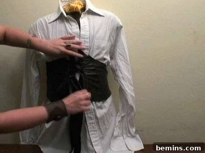 A person fitting a corset on a mannequin.