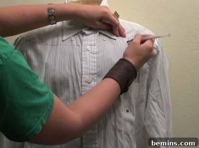 A person decorates a shirt for a pirate costume.