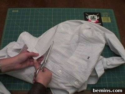 Woman cutting old formal full hands white shirt with scissors.