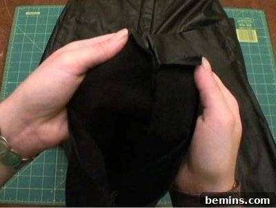 Leather pants being prepared on a green cutting mat for creating a pirate hat.