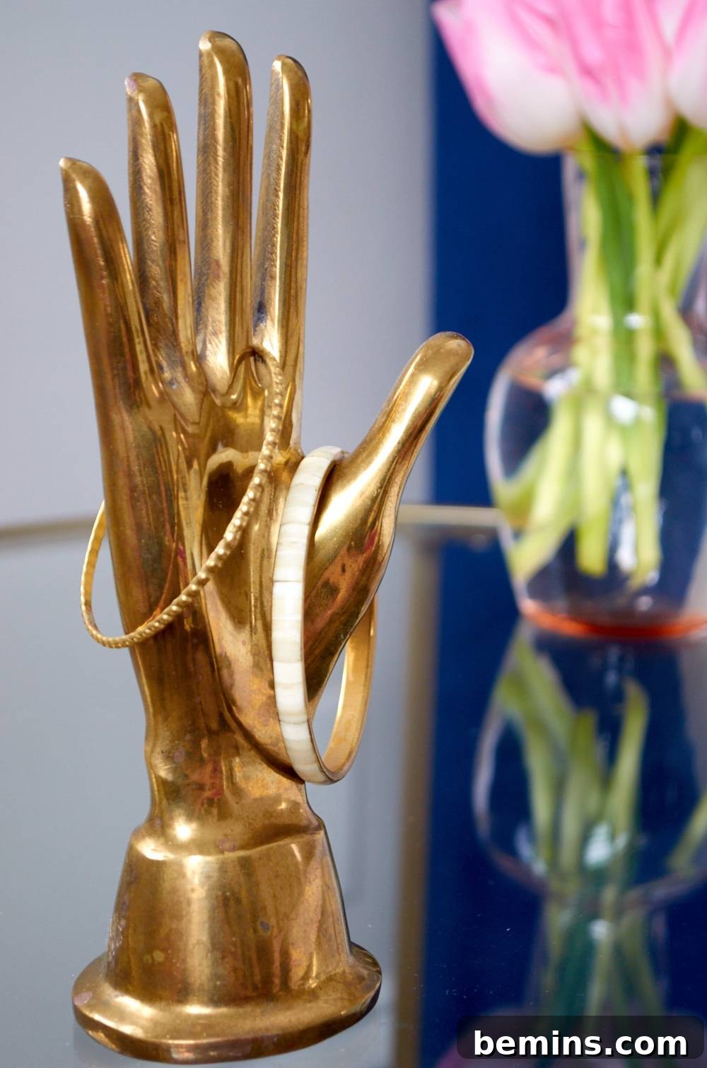 Gold hand statue holding bracelets