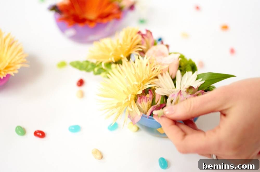 Close-up of flowers being arranged inside a decorated plastic Easter egg.