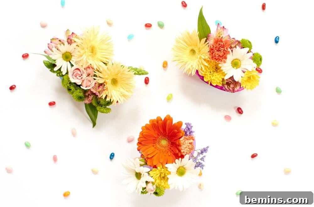 Three separate floral arrangements in decorated Easter eggs against a white background with jelly beans scattered throughout.