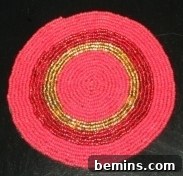 A striking coaster with red and gold seed beads, highlighting a rich color combination and elegant design for a sophisticated look.