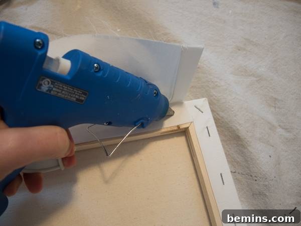 Gluing the fabric to the back of the canvas