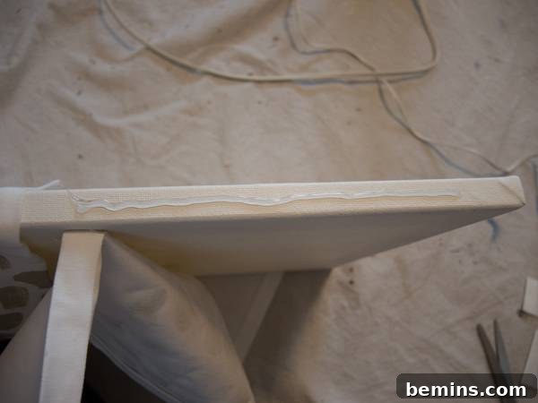 Gluing the sides of the fabric to the sides of the canvas
