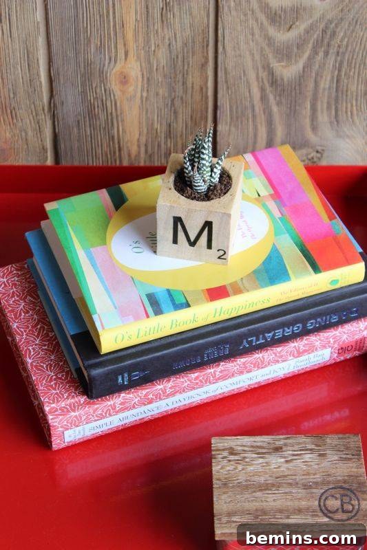 Several colorful books neatly stacked on a vibrant red table, showcasing a cozy reading nook.