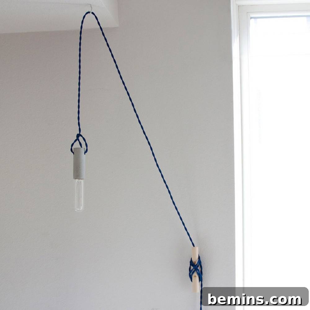 10 Stunning DIY Lighting Ideas No Electrician Required 11 A minimalist plug-in pendant light with a decorative bulb hanging from a string attached to a wall, offering simple and versatile illumination.