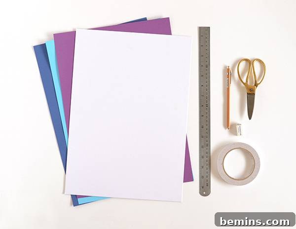 All materials laid out on a table: white card, colored papers, ruler, pencil, scissors, eraser, and glue stick