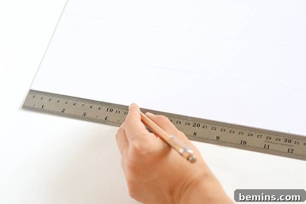 A hand using a ruler and pencil to draw faint grid lines on a white card