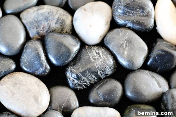 Black, grey, and white stones arranged on the bath mat
