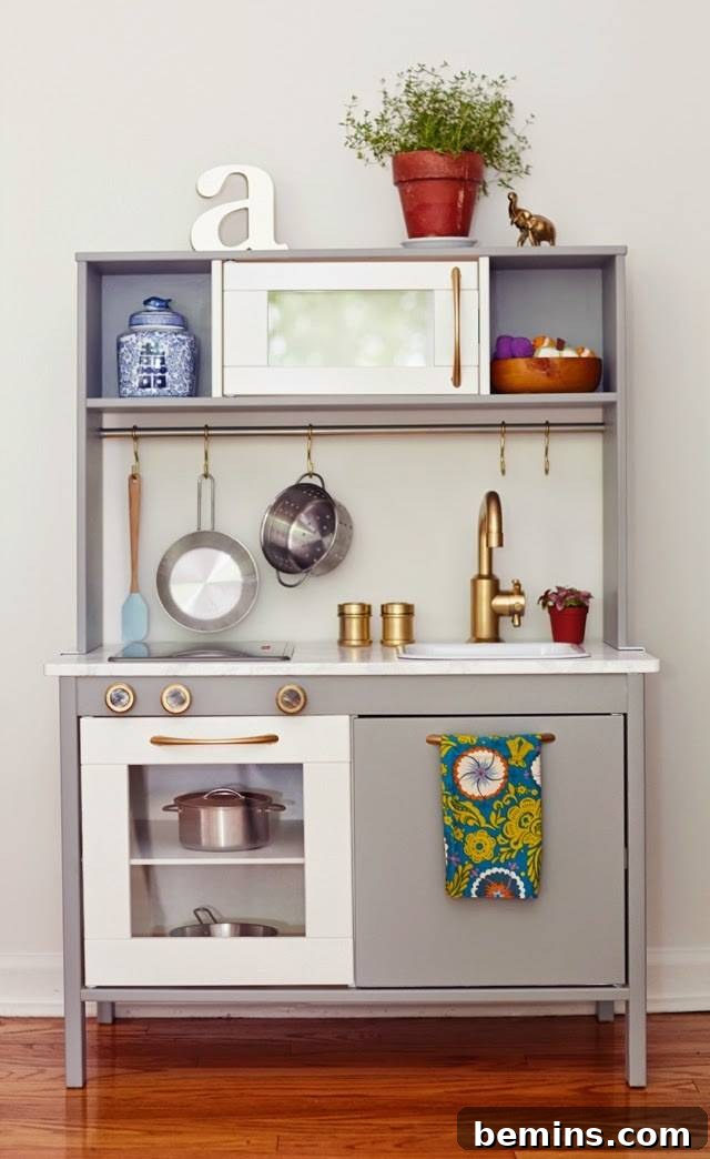 10 Clever IKEA Play Kitchen Transformations for Little Chefs 11 Subtle yet charming IKEA Duktig play kitchen with gray paint and a pretty teal towel, showcasing simple elegance.