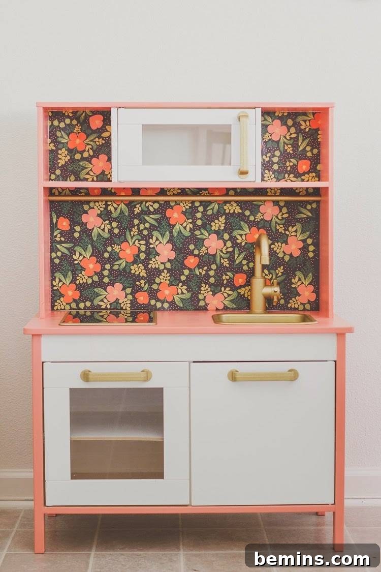 10 Clever IKEA Play Kitchen Transformations for Little Chefs 4 Elegant IKEA Duktig play kitchen featuring a new color scheme, gold hardware, and floral wallpaper backsplash.