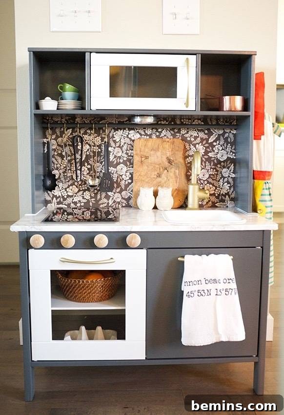 10 Clever IKEA Play Kitchen Transformations for Little Chefs 8 Monochromatic IKEA Duktig play kitchen with muted tones and black & white wallpaper backsplash for chic appeal.