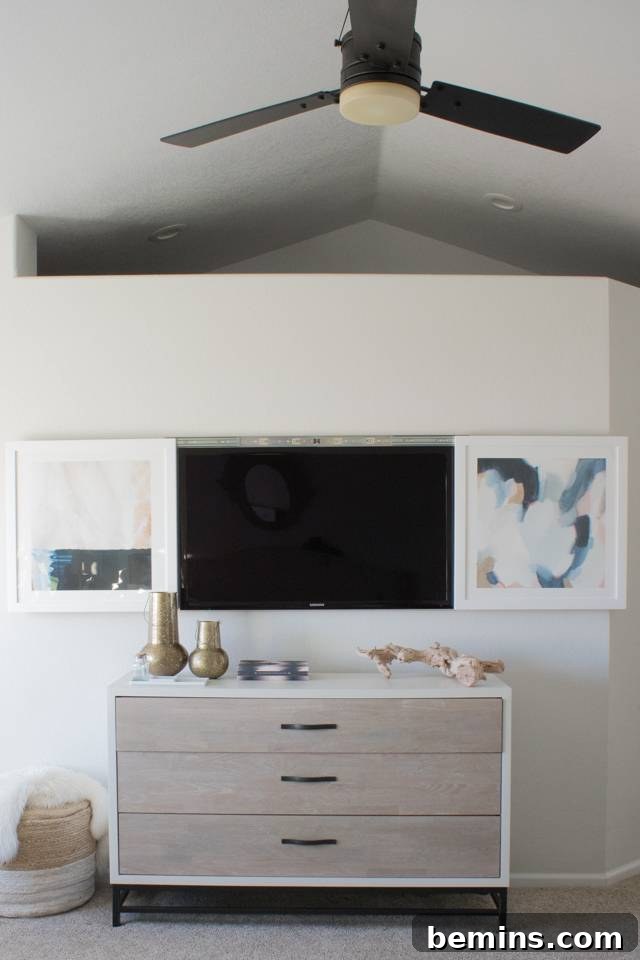 Living room featuring a TV hidden behind large sliding framed artwork