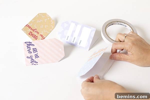Printable cheeky luggage tags showing gluing the two sides together