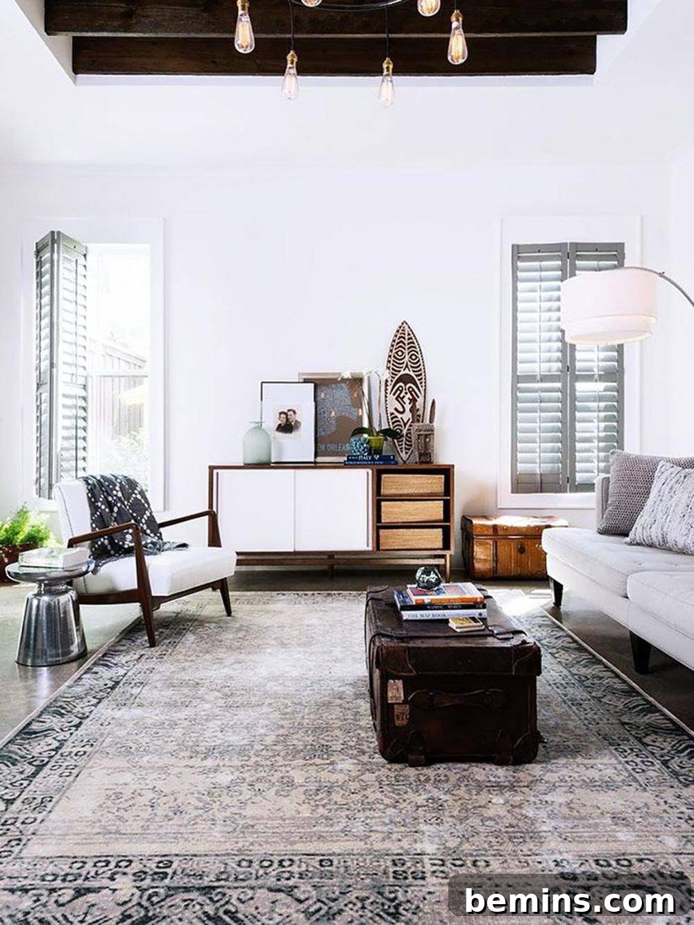 Living room anchored by a patterned rug with travel-inspired items