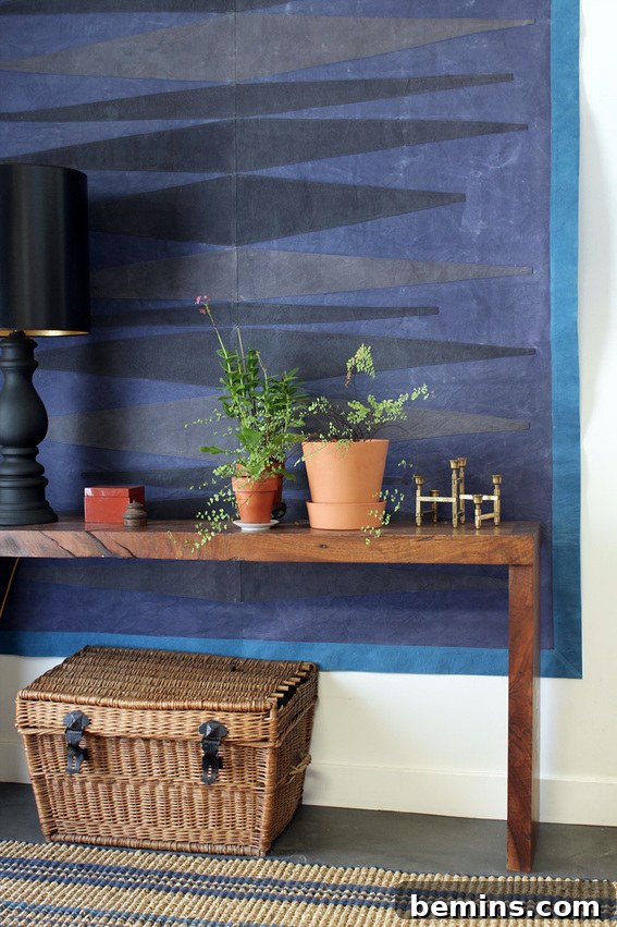 Two flower pots on a wooden surface against a blue wall. DIY Canvas Drop Cloth Wall Art Idea.