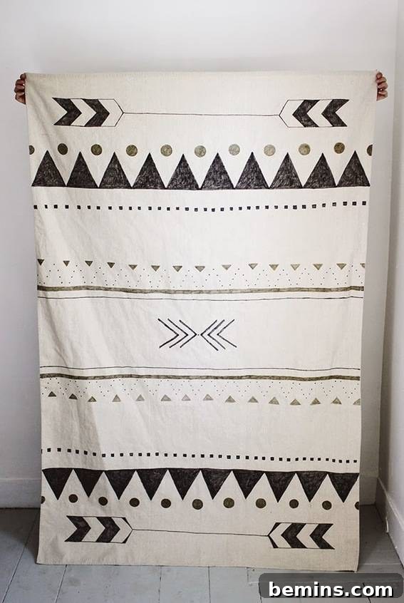 A person is hanging a designer blanket. Canvas Drop Cloth Wall Hanging Idea.