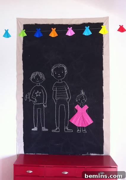 A black board has a chalk drawing of three people. Chalk Board Painted Drop Cloth Wall Art.
