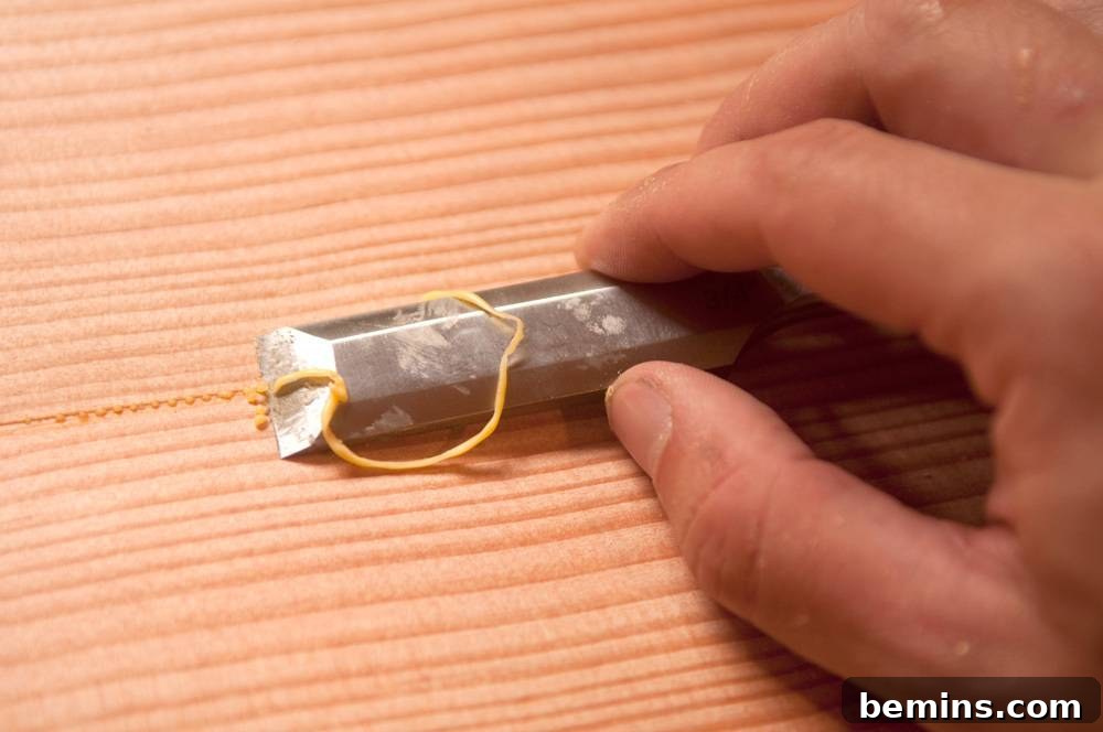 Measuring a piece of wood with a small metal object tied to a yellow string.