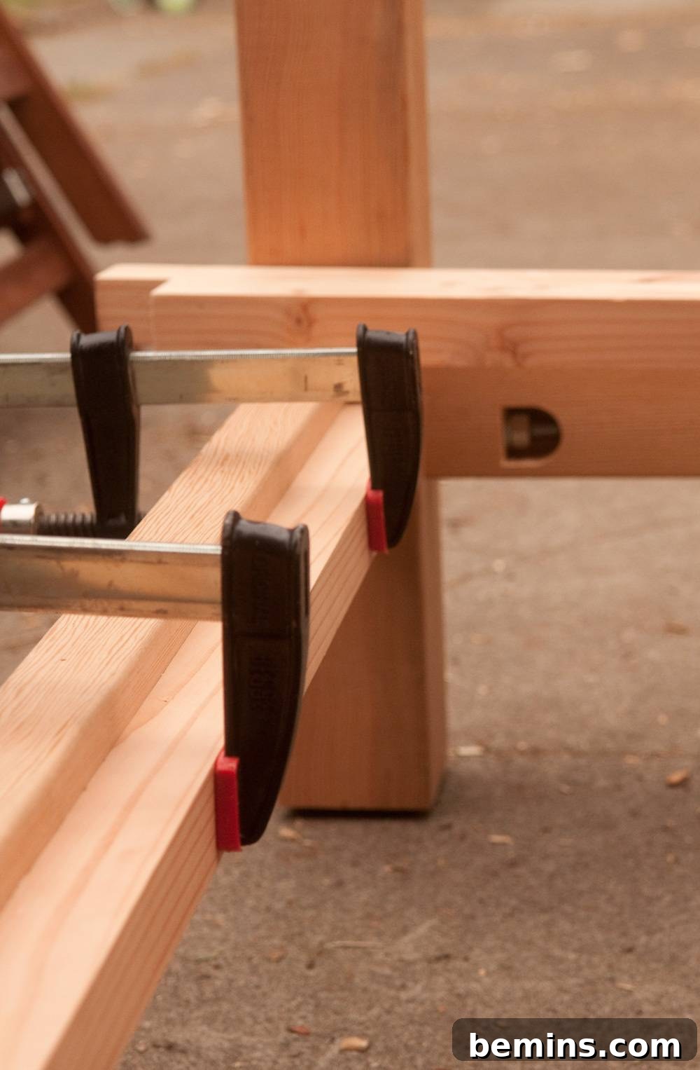 Two clamps holding together a piece of wood.