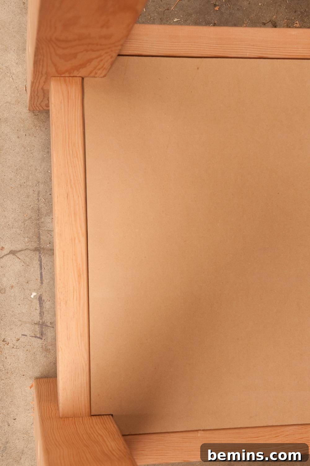 Two light colored wooden posts attached to a light colored board.