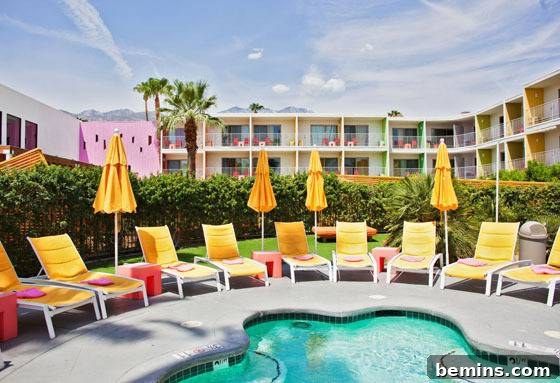 The Saguaro Hotel Palm Springs pool area with iconic yellow chairs and colorful architecture.