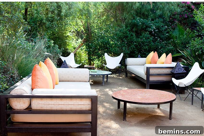 The Parker Palm Springs patio featuring eclectic and mid-century modern furniture under lush greenery.