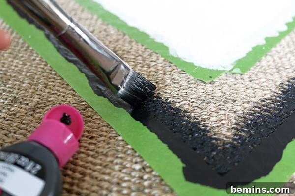 Dabbing fabric paint onto a flatwoven outdoor rug