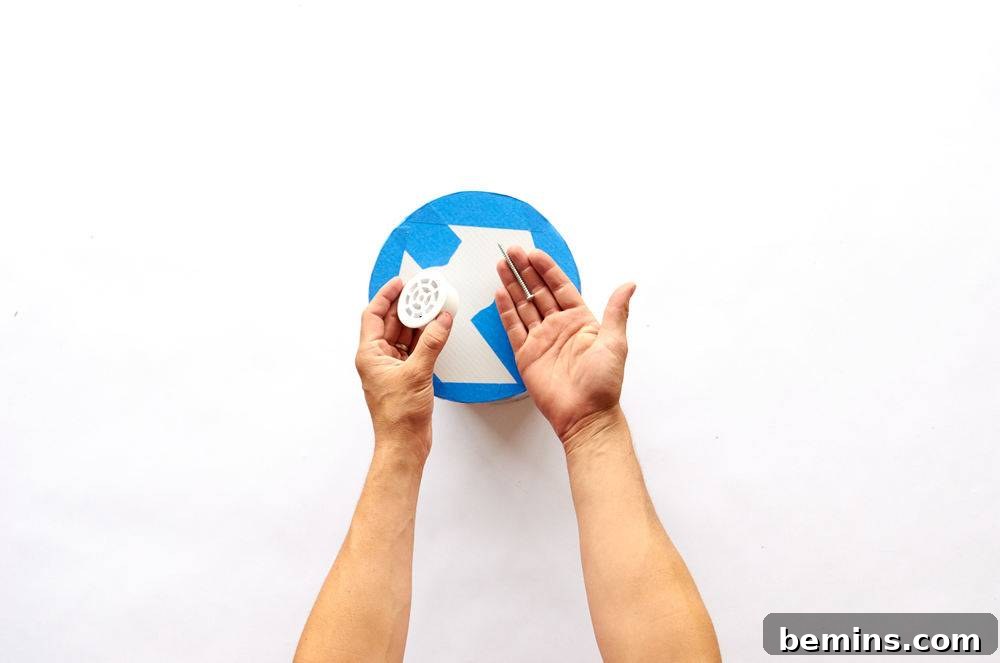 A person waving their hands over a blue and white object.