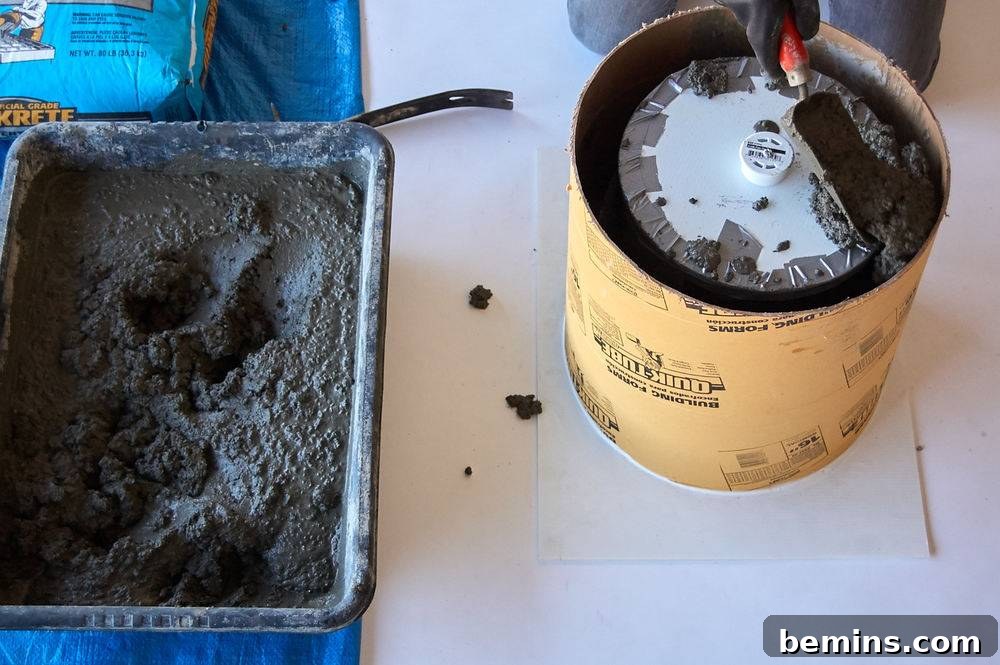 Cement is being mixed in a container on a blue tarp.