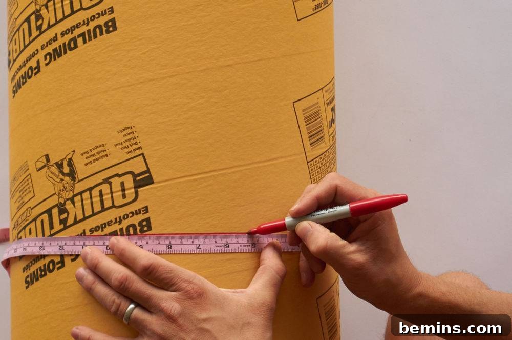 A person is using a red marker and a soft measuring tape to draw a line around a cylindrical object.