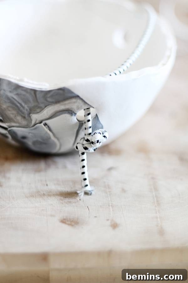 Create Beautiful DIY Hanging Clay Planters 10 Threading cord through a clay planter hole and making a knot