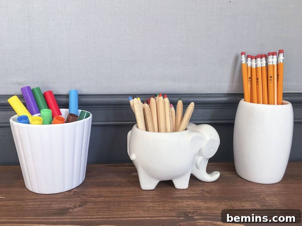Pencils, pens, and markers organized in white containers.